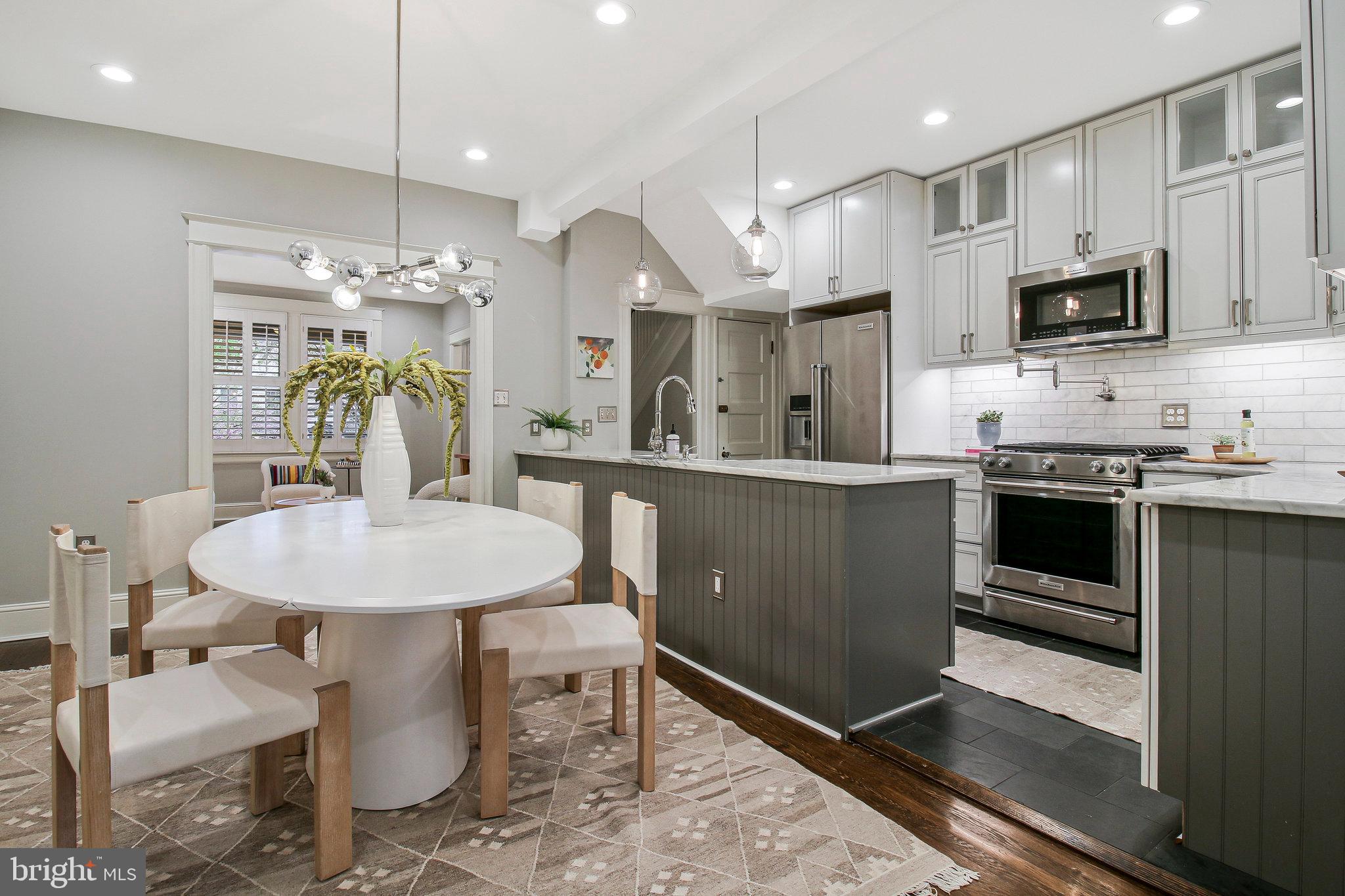 239 11th Street Southeast Washington, DC 20003 - Photo 11 of 53 a kitchen with stainless steel appliances kitchen island granite countertop a sink a stove a microwave a dining table and chairs