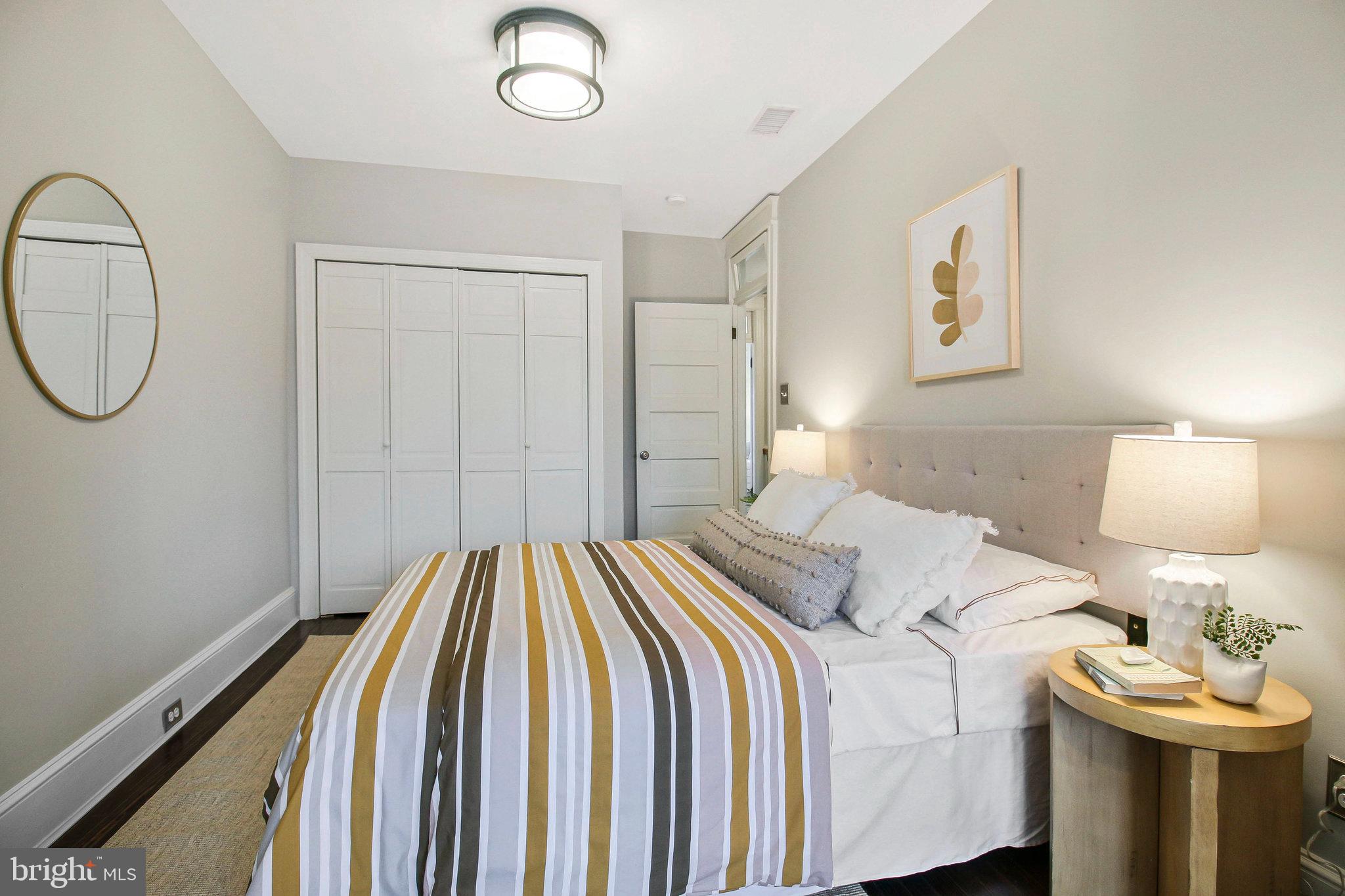 239 11th Street Southeast Washington, DC 20003 - Photo 33 of 53 a bedroom with a bed and a chandelier