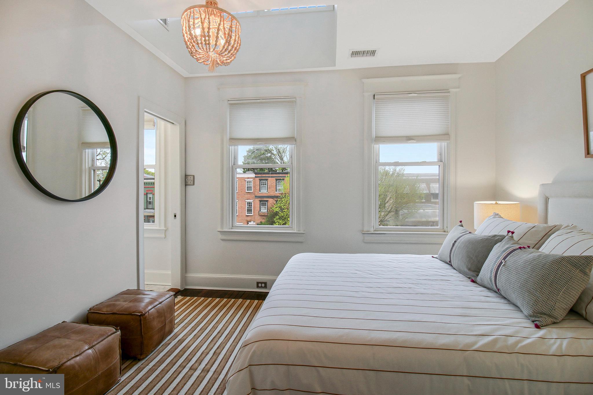 239 11th Street Southeast Washington, DC 20003 - Photo 38 of 53 a bedroom with a bed and a chandelier
