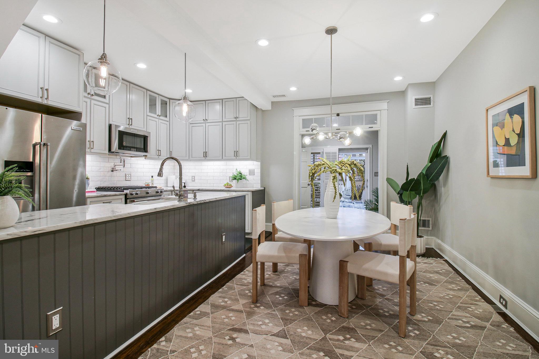 239 11th Street Southeast Washington, DC 20003 - Photo 10 of 53 a kitchen with a table chairs refrigerator and microwave