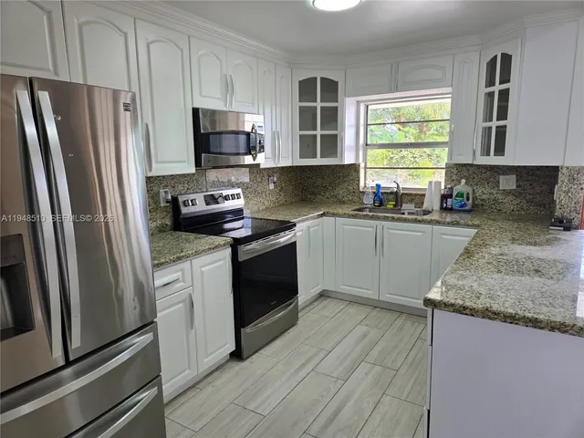 a kitchen with a sink stove and refrigerator