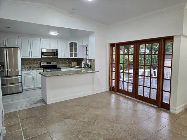 a kitchen with stainless steel appliances granite countertop a stove top oven a sink a refrigerator and a granite counter tops