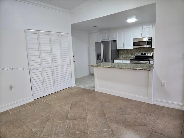 a kitchen with stainless steel appliances granite countertop a refrigerator and a stove top oven