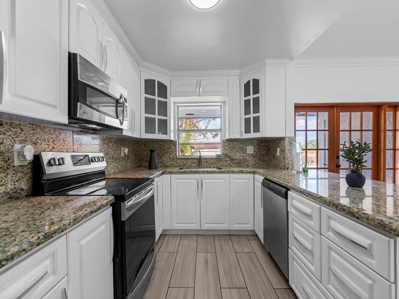 25921 Southwest 130th Avenue Homestead, FL 33032 - Photo 15 of 38 a kitchen with stainless steel appliances granite countertop a stove sink and cabinets