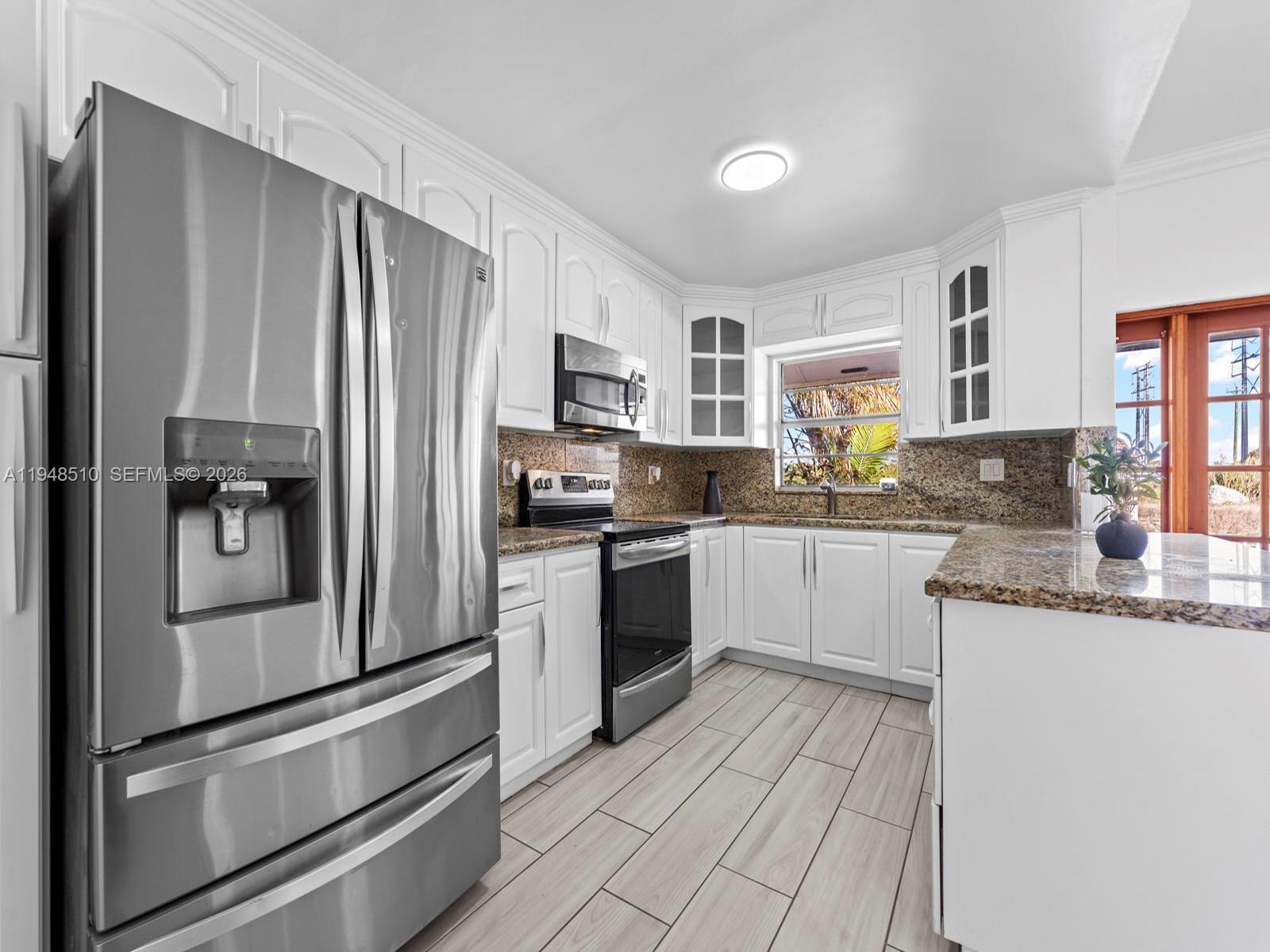 25921 Southwest 130th Avenue Homestead, FL 33032 - Photo 17 of 38 a kitchen with granite countertop a refrigerator stove and sink