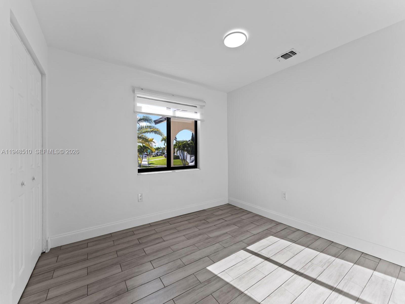 25921 Southwest 130th Avenue Homestead, FL 33032 - Photo 20 of 38 an empty room with wooden floor and windows