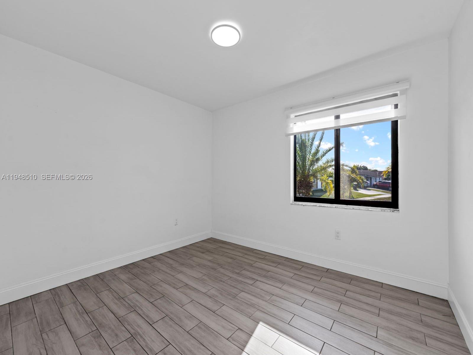 25921 Southwest 130th Avenue Homestead, FL 33032 - Photo 22 of 38 an empty room with wooden floor and window