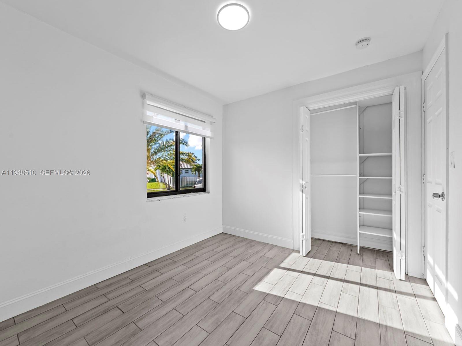 25921 Southwest 130th Avenue Homestead, FL 33032 - Photo 23 of 38 wooden floor in an empty room with a window
