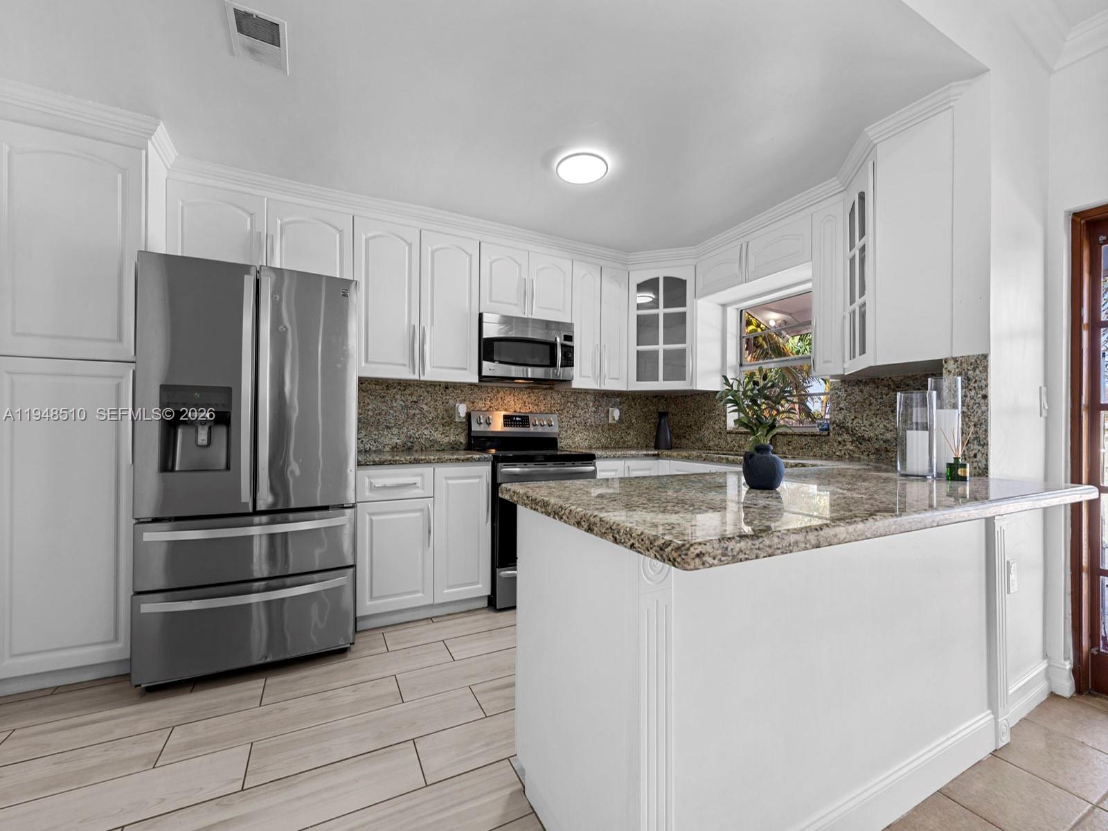 25921 Southwest 130th Avenue Homestead, FL 33032 - Photo 30 of 38 a kitchen with kitchen island granite countertop stainless steel appliances and cabinets