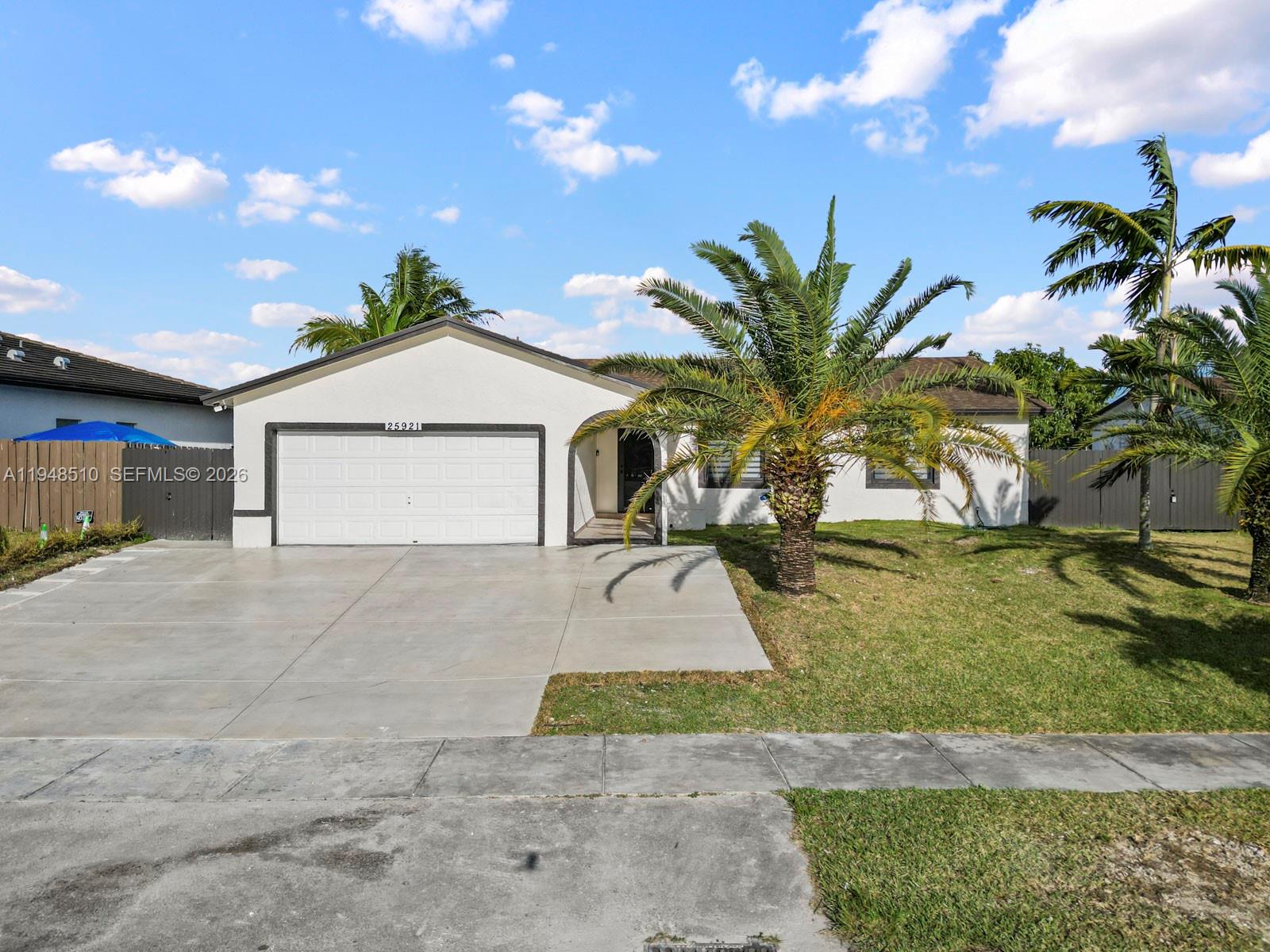 25921 Southwest 130th Avenue Homestead, FL 33032 - Photo 3 of 38 a view of a house with a yard and garage