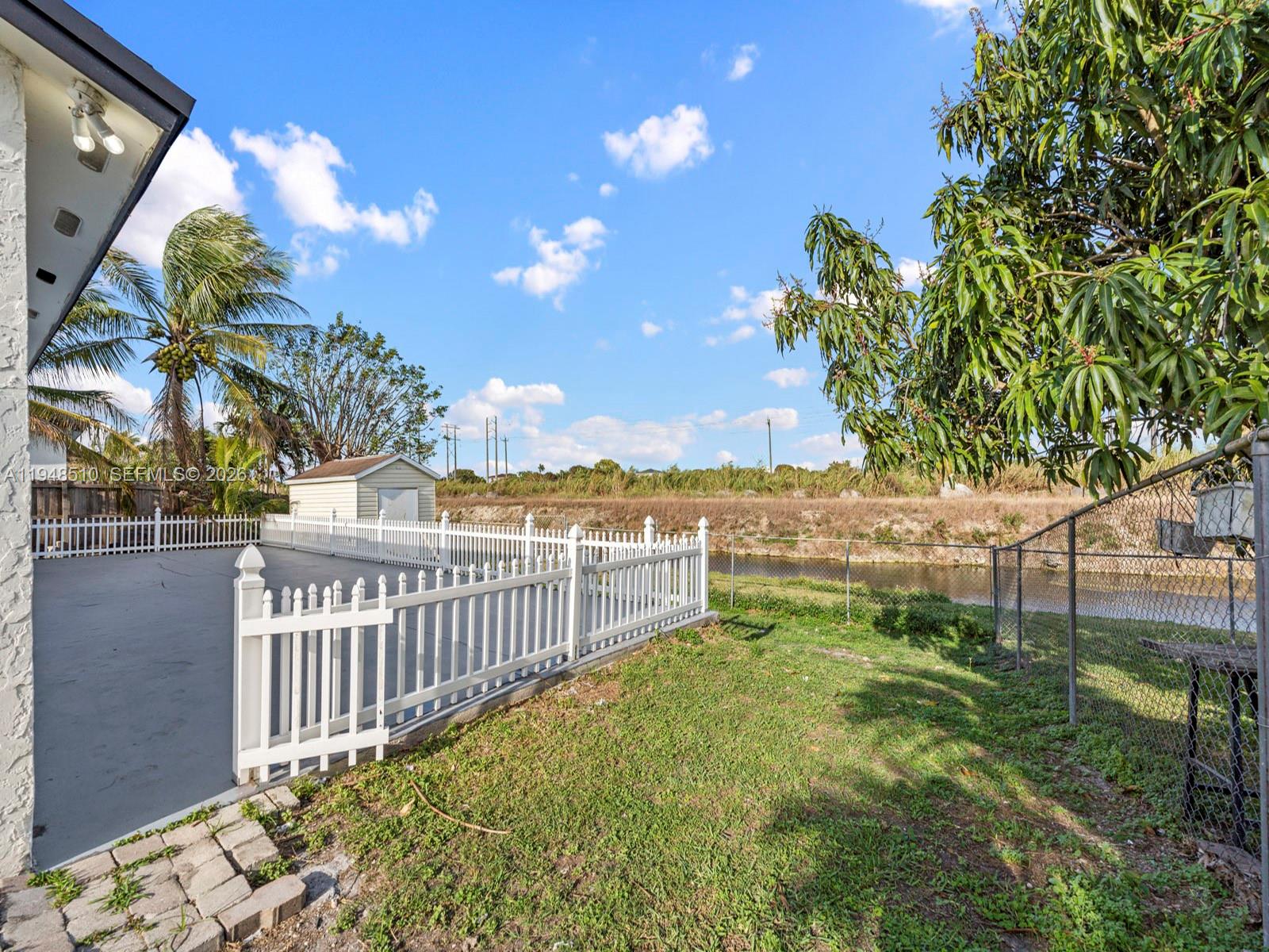 25921 Southwest 130th Avenue Homestead, FL 33032 - Photo 37 of 38 a view of a yard with plants and wooden fence