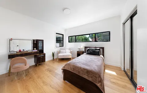 a bedroom with bed and glass window