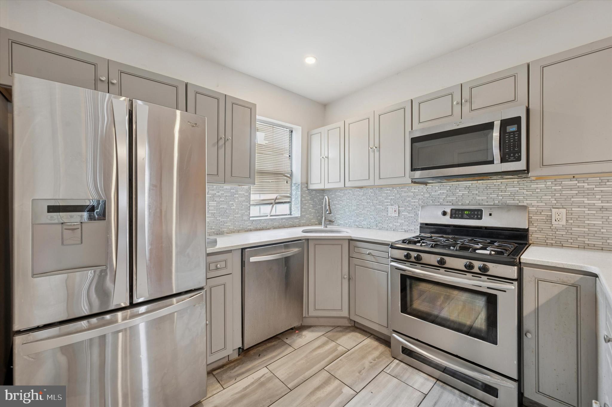 249 West Calvert Street Philadelphia, PA 19120 - Photo 10 of 25 a kitchen with granite countertop a refrigerator stove and microwave