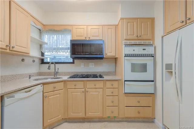 a kitchen with granite countertop cabinets stainless steel appliances and a sink
