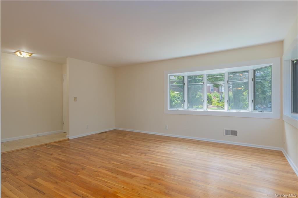 55 East Devonia Avenue, Unit 1 Mount Vernon, NY 10552 - Photo 7 of 24 a view of an empty room with wooden floor and a window