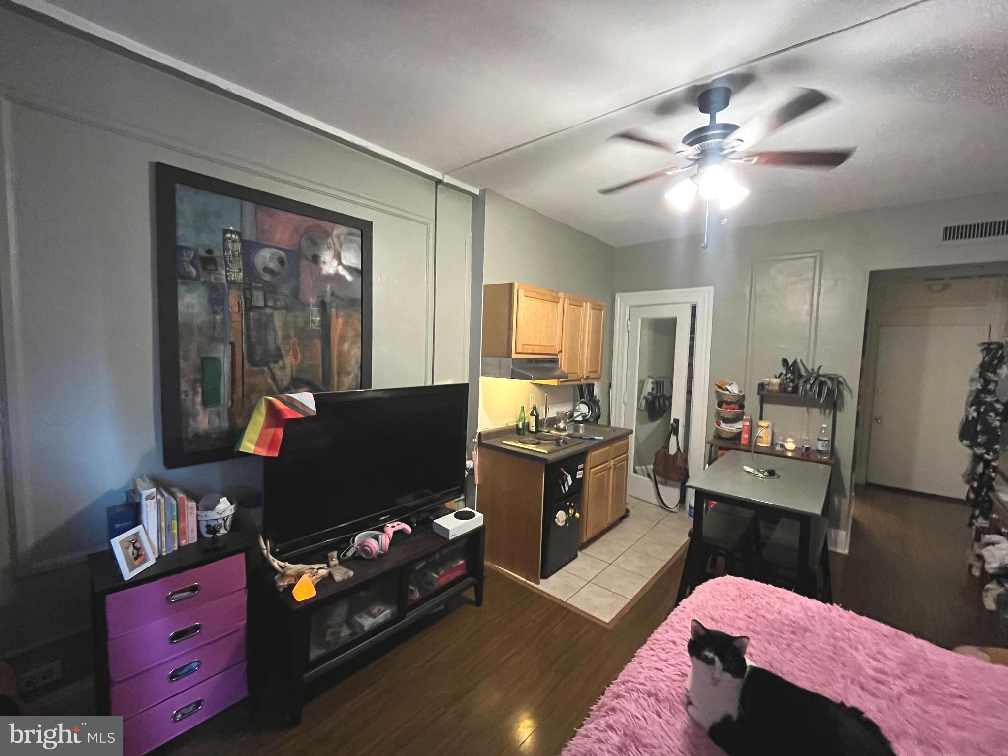 1324 Locust Street, Unit 501 Philadelphia, PA 19107 - Photo 6 of 8 a living room with furniture and a flat screen tv