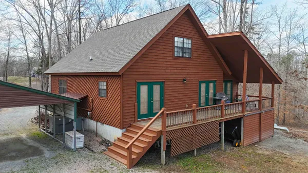 a view of a house with a yard and wooden fence