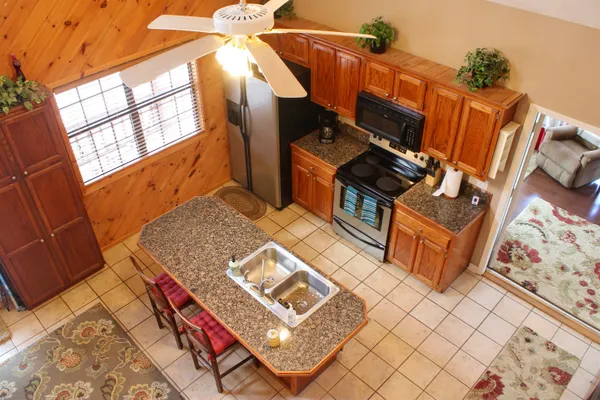 a kitchen with granite countertop a refrigerator and a stove top oven