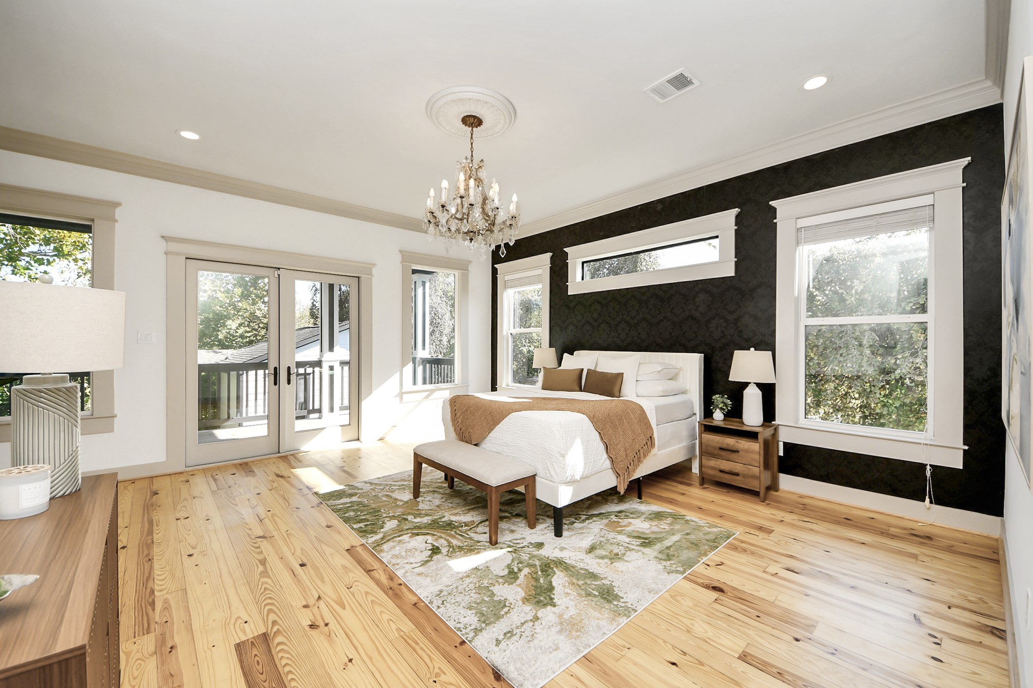 1202 Archer Street Houston, TX 77009 - Photo 6 of 46 wners retreat features custom textured walls, a luxurious chandelier, and abundant natural light from large windows. The room opens to a balcony through glass doors, offering a serene view. Hardwood floors complete the inviting atmosphere.