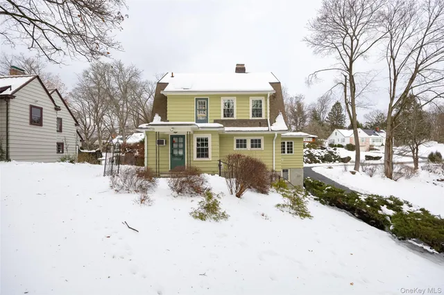 a front view of a house with a yard covered in snow