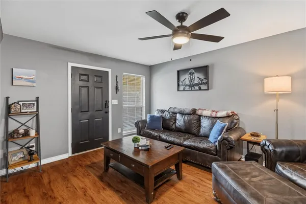 a living room with furniture and a ceiling fan