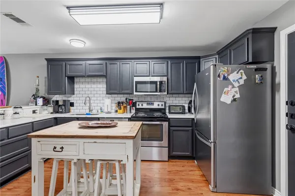 a kitchen with stainless steel appliances a stove a sink and a refrigerator