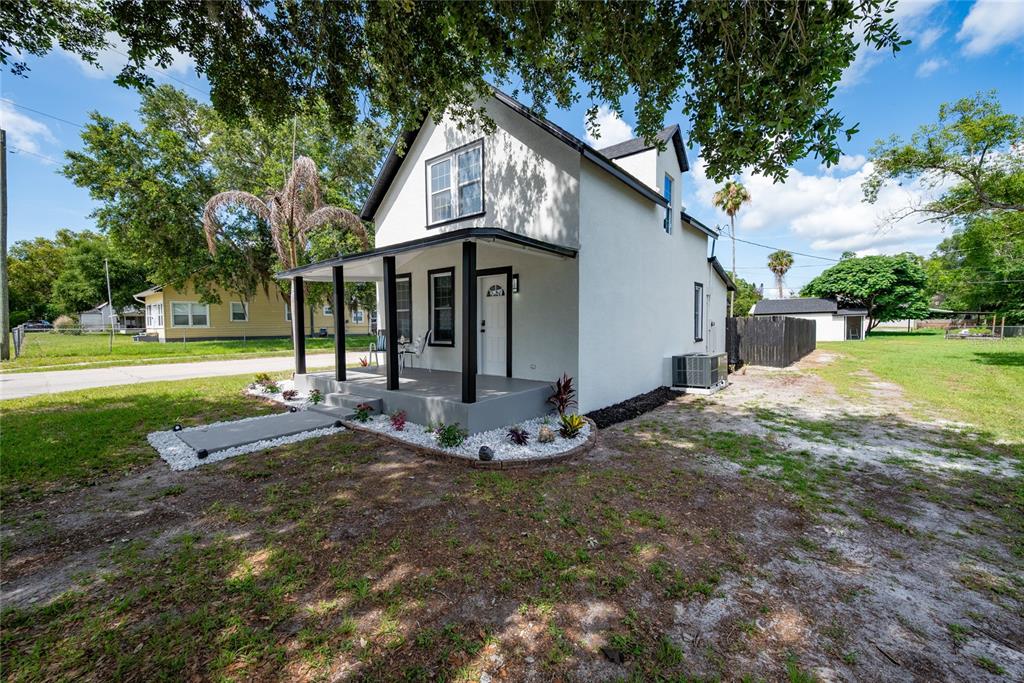 922 Delaware Avenue St. Cloud, FL 34769 - Photo 2 of 31 a view of a white house with a yard and large tree