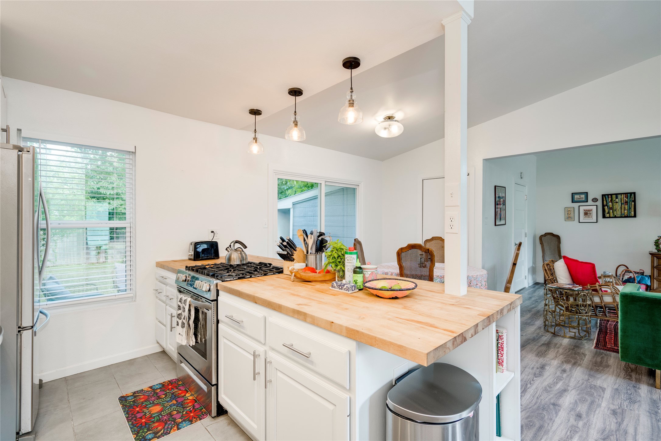 5300 Halmark Drive Austin, TX 78723 - Photo 11 of 40 A well-lit kitchen with sleek stainless steel appliances and a butcher block island, connecting seamlessly to a bright dining area.