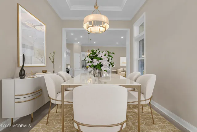 a dining room with furniture and a large mirror with wooden floor