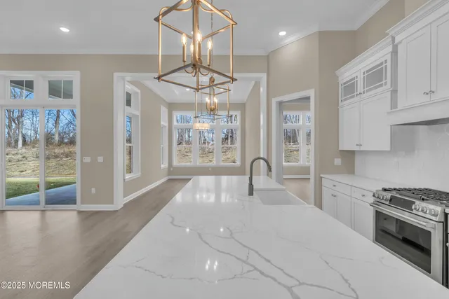a kitchen with stainless steel appliances kitchen island granite countertop a stove and a view of living room