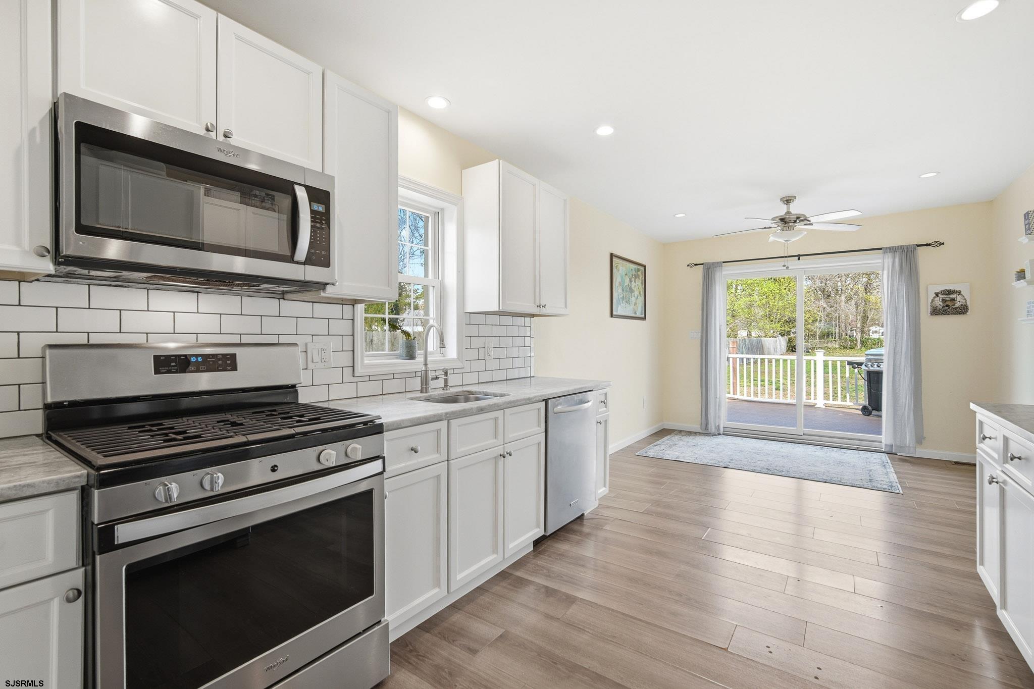 395 1st Street Northfield, NJ 08225 - Photo 12 of 54 a kitchen with stainless steel appliances a stove microwave and sink