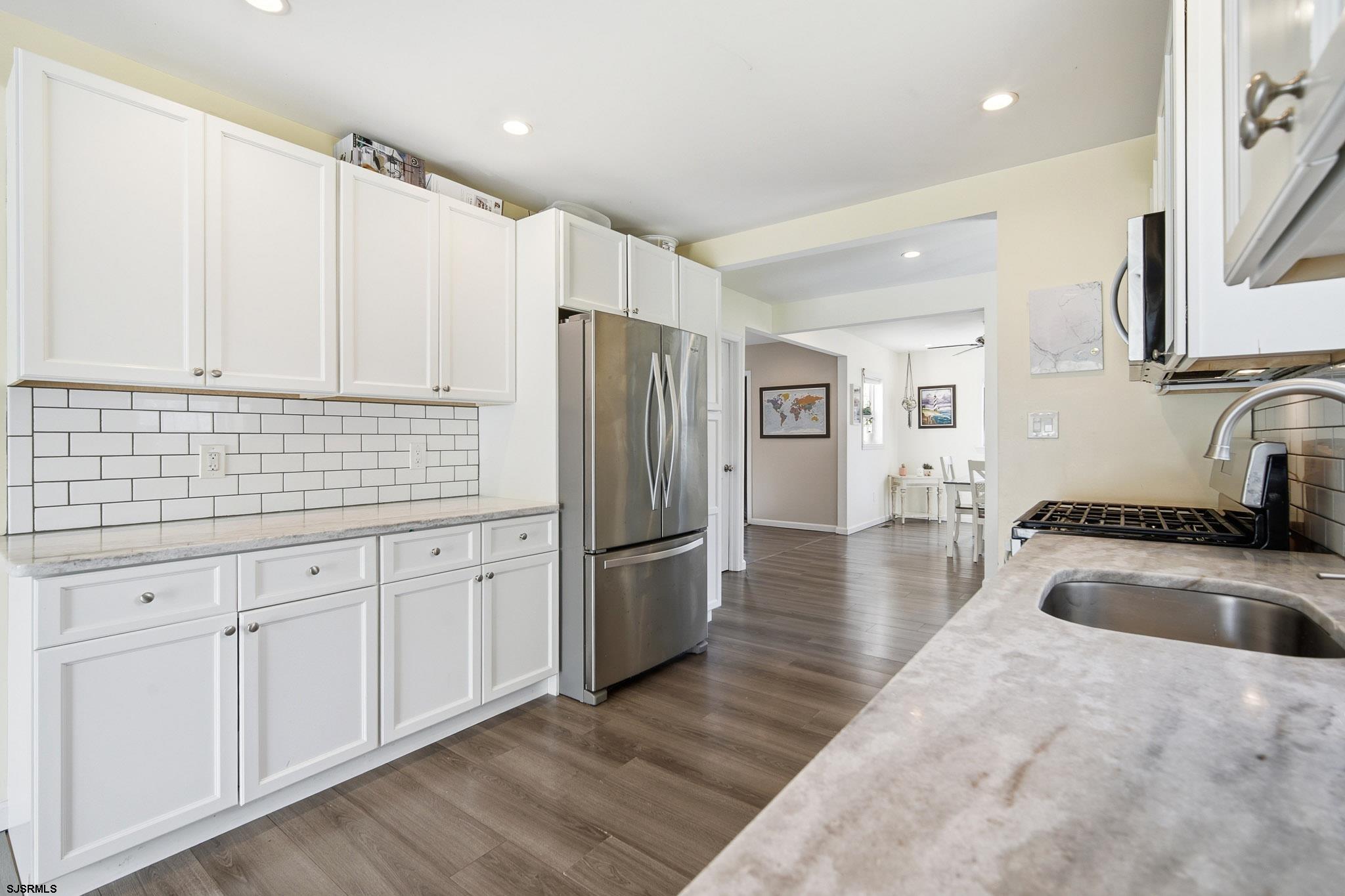 395 1st Street Northfield, NJ 08225 - Photo 14 of 54 a kitchen with granite countertop a refrigerator and a sink