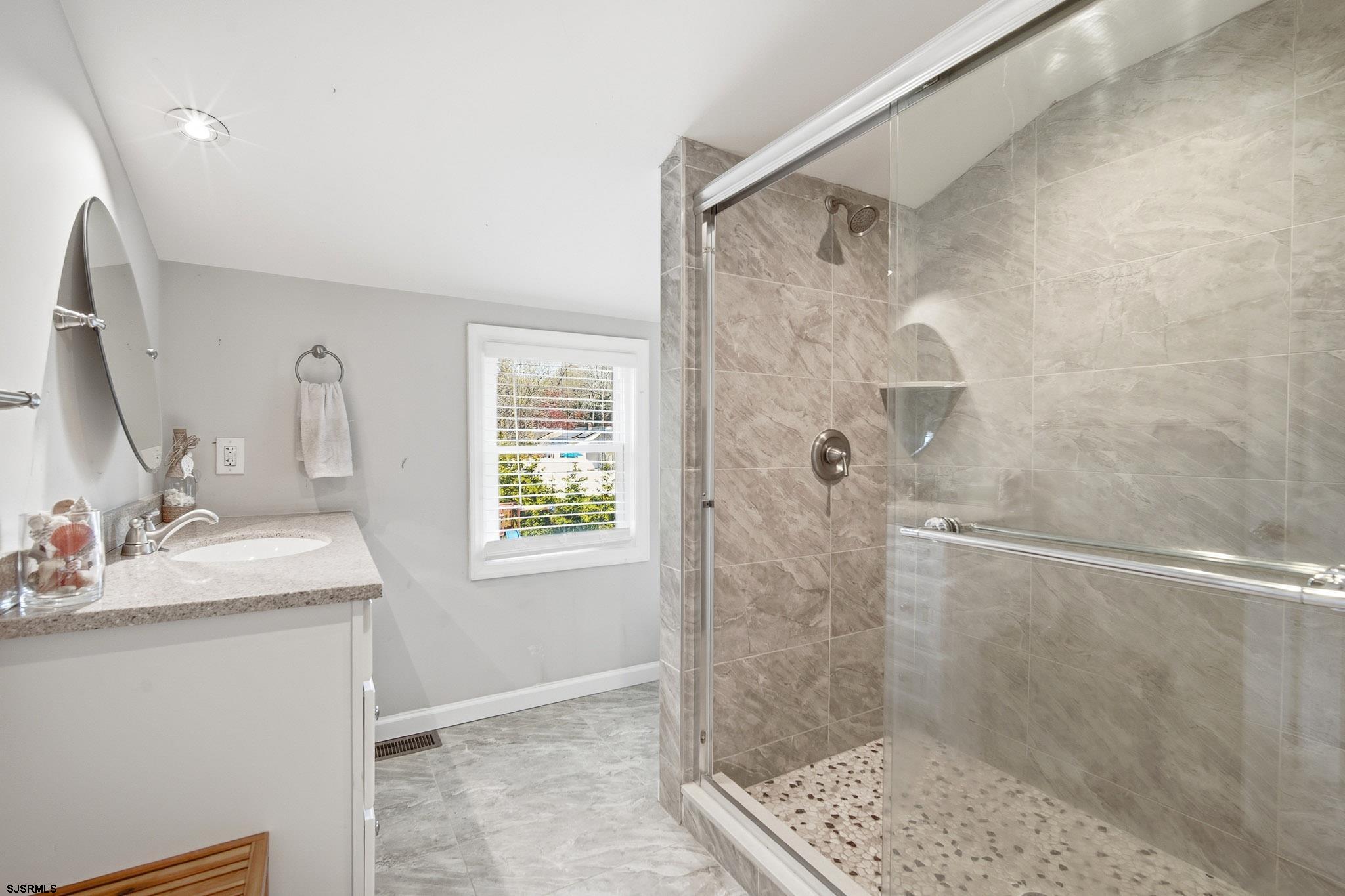 395 1st Street Northfield, NJ 08225 - Photo 24 of 54 a bathroom with a granite countertop shower sink and mirror