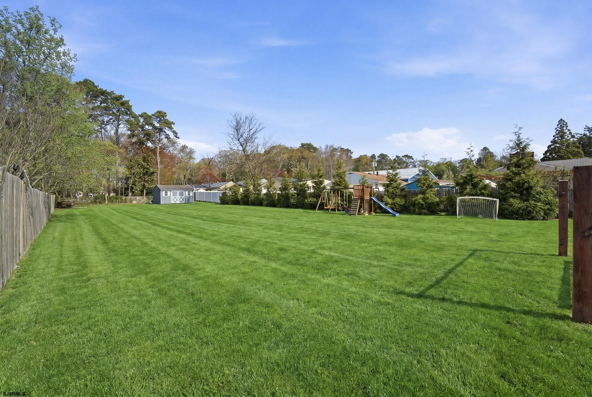 395 1st Street Northfield, NJ 08225 - Photo 31 of 54 a view of a grassy field with trees