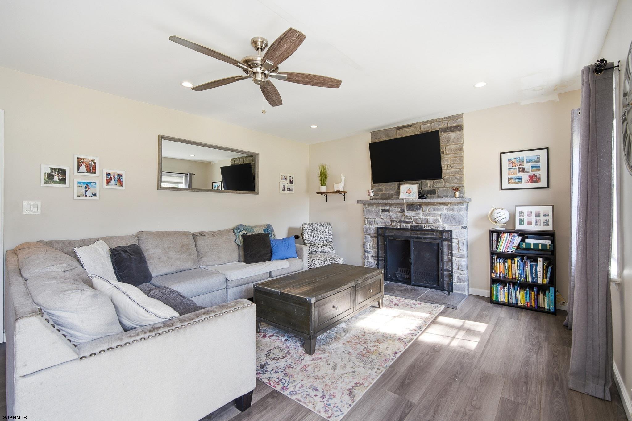 395 1st Street Northfield, NJ 08225 - Photo 6 of 54 a living room with furniture a flat screen tv and a fireplace