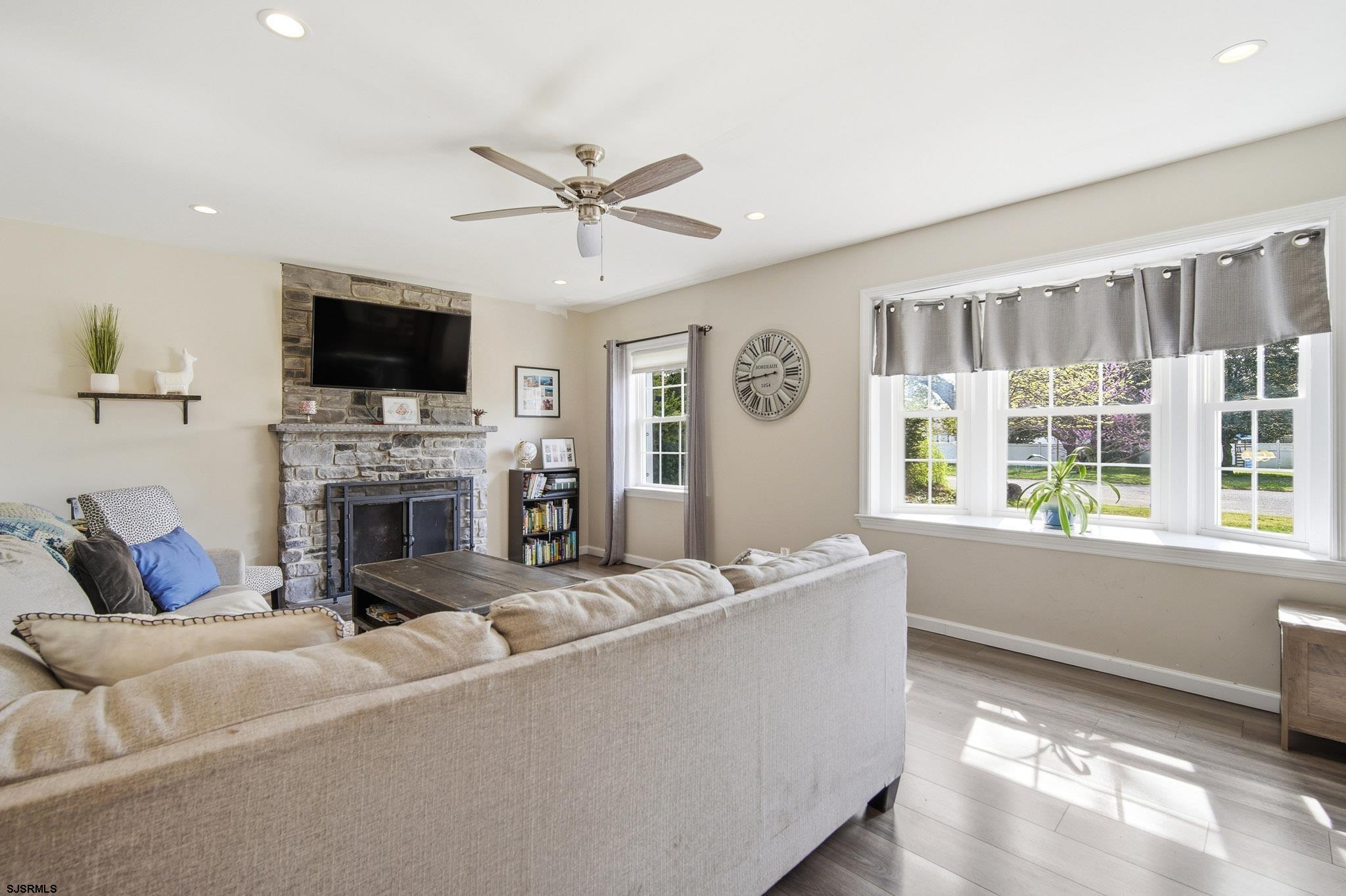 395 1st Street Northfield, NJ 08225 - Photo 7 of 54 a living room with furniture a fireplace and a flat screen tv