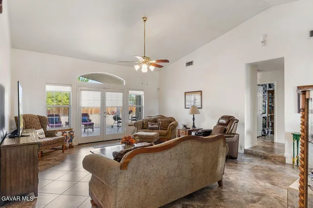 a living room with furniture a flat screen tv and a large window