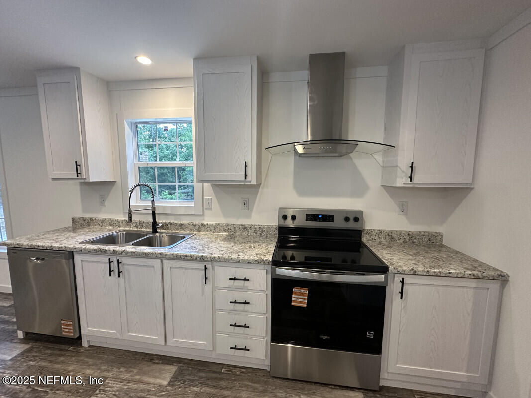 138 Nichols Road Florahome, FL 32140 - Photo 12 of 27 a kitchen with granite countertop a stove sink and cabinets