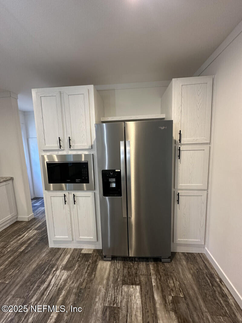 138 Nichols Road Florahome, FL 32140 - Photo 13 of 27 a view of a refrigerator in kitchen and wooden floor