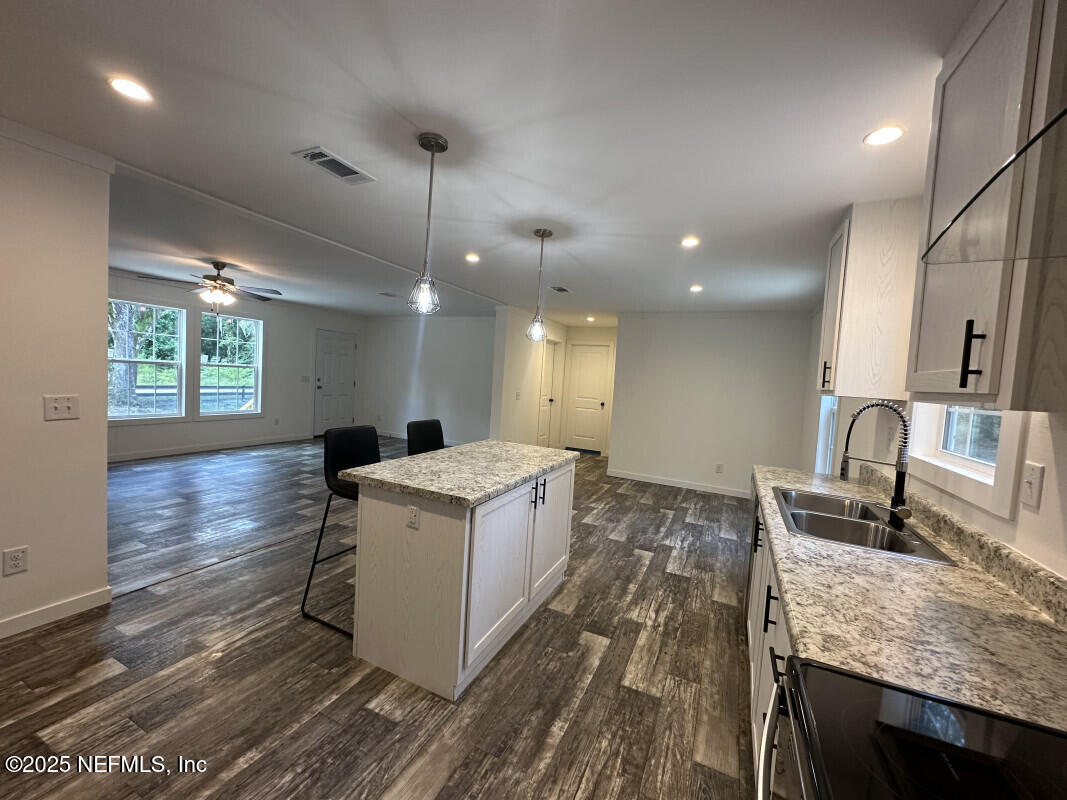 138 Nichols Road Florahome, FL 32140 - Photo 14 of 27 a kitchen with a sink stove and wooden floor