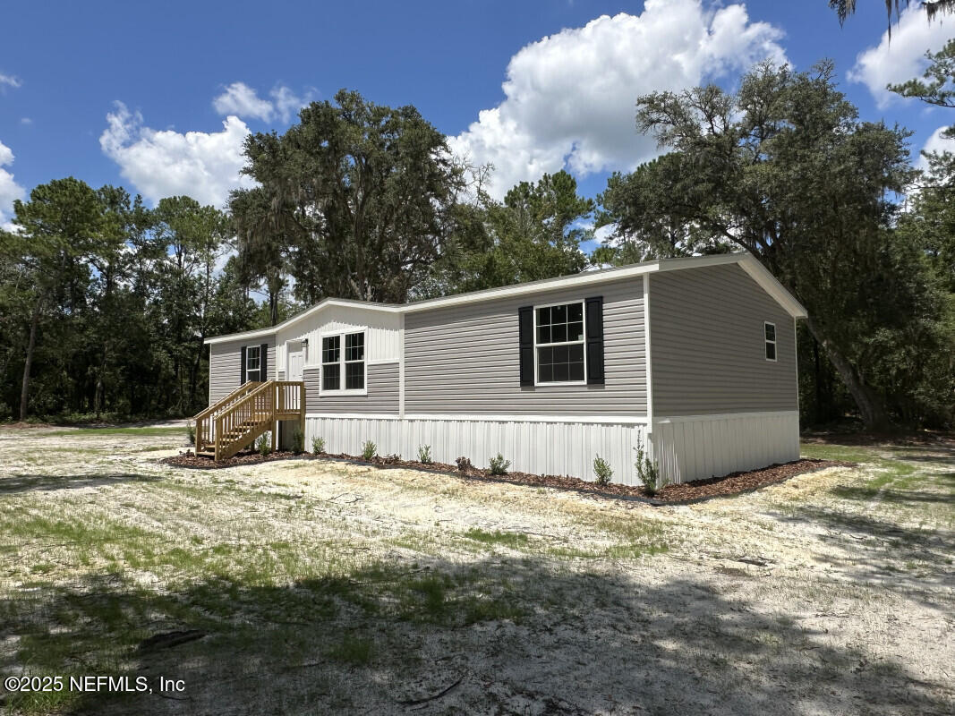 138 Nichols Road Florahome, FL 32140 - Photo 6 of 27 a view of a house with a yard covered with snow in the background