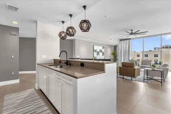 a large kitchen with lots of counter space a sink and stainless steel appliances