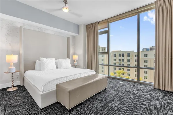 a spacious bedroom with a bed and a refrigerator