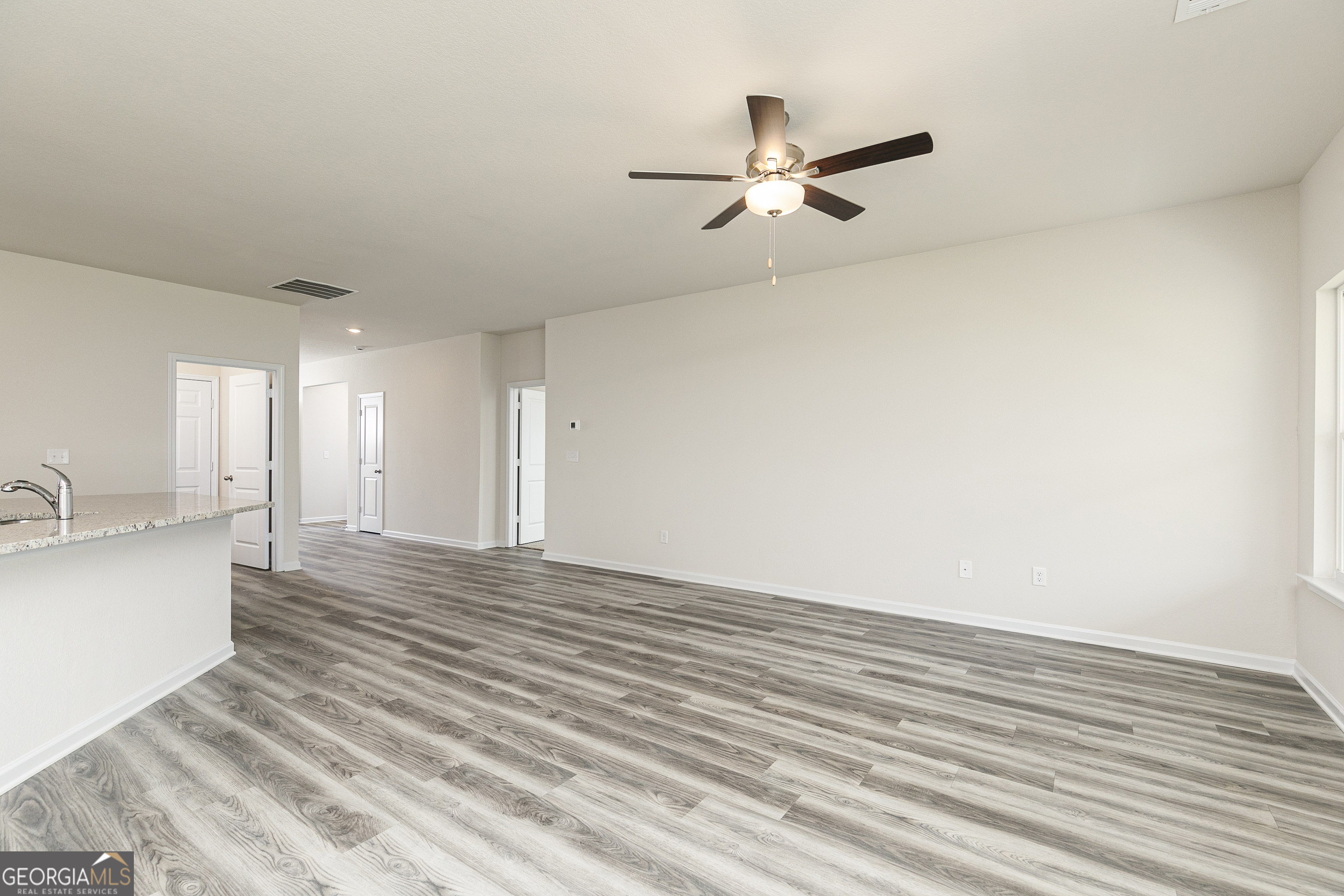 632 Slate Road Conyers, GA 30013 - Photo 8 of 26 a view of a livingroom with a ceiling fan and wooden floor