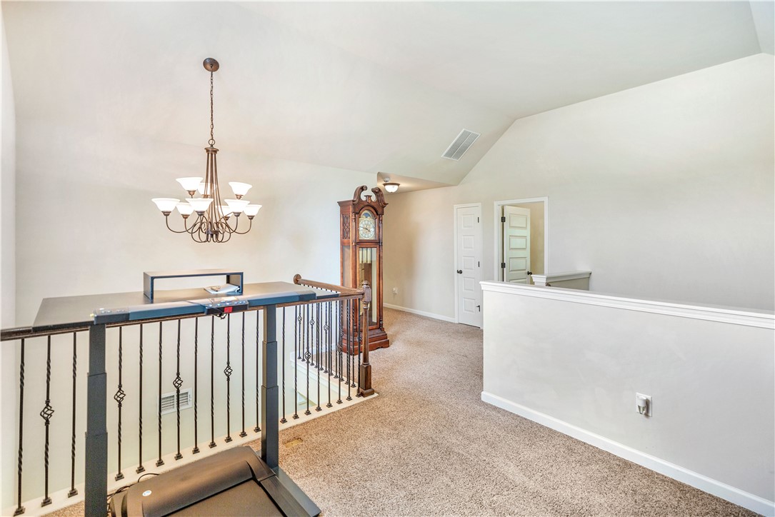 144 Buckland Drive Anderson, SC 29621 - Photo 12 of 48 A graceful chandelier illuminates the carpeted loft space with vaulted ceilings.