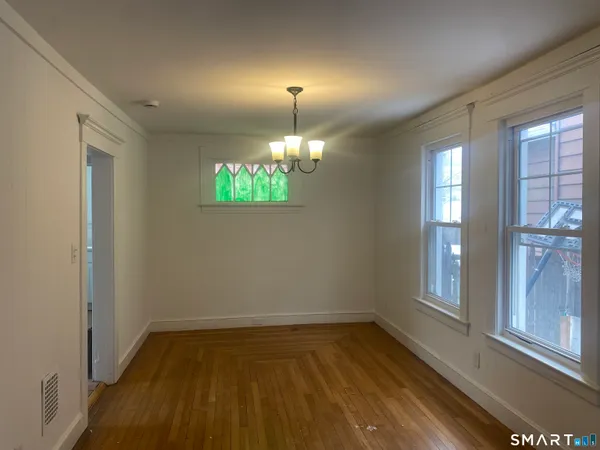 a view of a room with wooden floor and a window