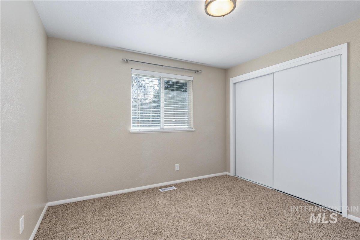 2103 North Hampton Road Boise, ID 83704 - Photo 21 of 40 Unfurnished bedroom with a closet, light carpet, and a textured wall