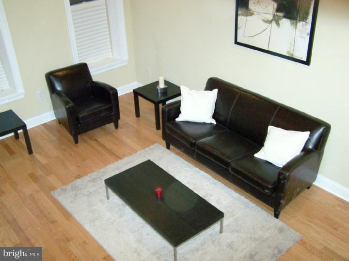 a living room with furniture rug and wooden floor