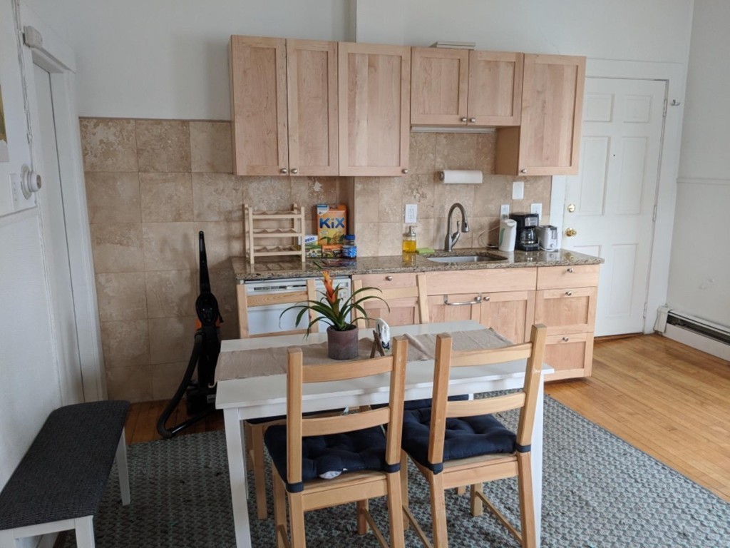 a kitchen with a dining table chairs and cabinets