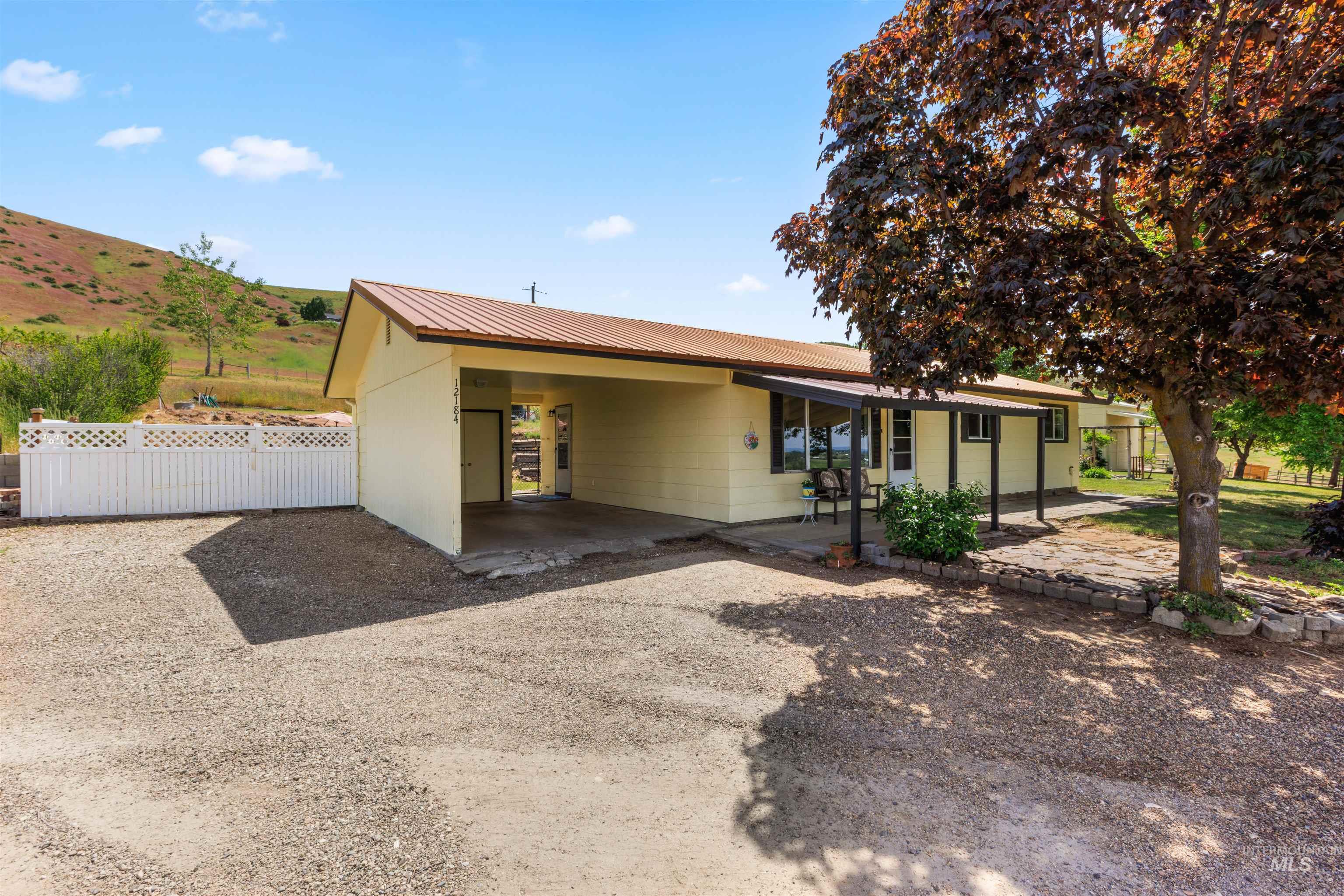 12184 Hill Road Payette, ID 83661 - Photo 4 of 35 Single-story residence featuring a covered carport, metal roof, and a gravel driveway